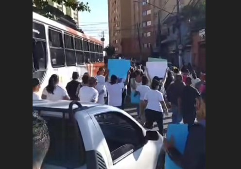 Com camisetas brancas e cartazes, moradores das áreas 13 e 14 realizam protesto pacífico
